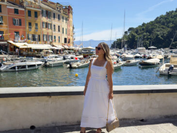 Travel blogger in a neutral linen outfit standing at Portofino Bay, showcasing what to wear in Portofino
