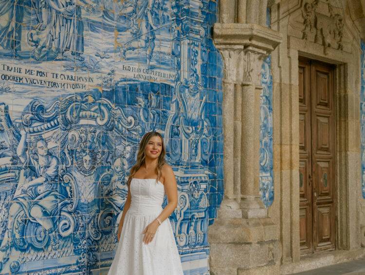 Woman standing in front of Porto Cathedral’s blue-tiled church façade wearing a neutral linen outfit, embodying effortless European style against the city’s iconic azulejo backdrop.